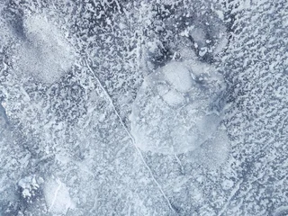 A macro texture of frozen ice with air bubbles and natural patterns on Lake Baikal. Abstract surface detail of winter cold.  © Viks_jin