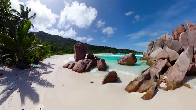 A hidden bay with crystal-clear turquoise waters, towering granite rock formations and white sand beach. Seychelles, La Digue. Anse Cocos.