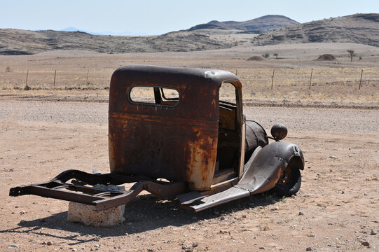 Old rusty car near a road in the Namib Desert