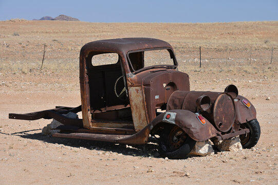 Old rusty car near a road