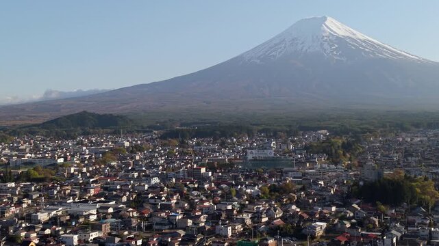 Aerial view of Mount Fuji towering over Fujiyoshida city in Yamanashi, Japan.