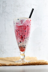 A glass of milkshake with tapioca and berry syrup © Irina