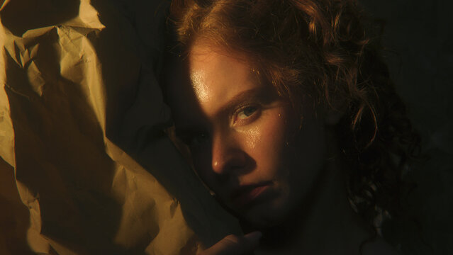 Woman Surrounded by Darkness Turns Toward Warm Light, Suggesting Inner Strength, Clarity, Emotional Renewal. Poetic Portrait Represents Hope, Resilience, Finding New Perspective. Sense of Worthiness.