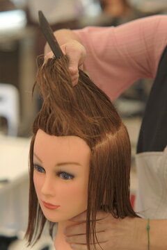Close-up shot of a professional hairstylist's hands precisely cutting and styling hair in a modern beauty salon