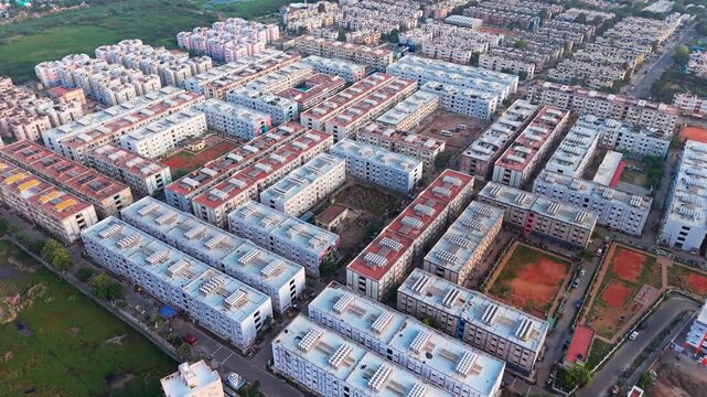 Aerial view of a large residential apartment complex with rows of buildings, flat roofs, and surrounding green spaces in Chennai, Tamil Nadu, India.