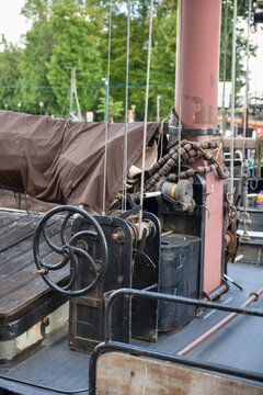 Vintage Sailboat Deck With Mast, Winch, Ropes and Covered Boom in Harbor Rigging