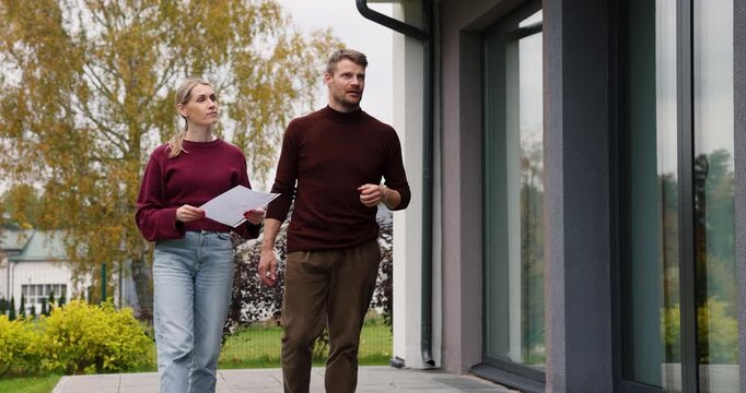 Real estate agent showing modern house to client. Realtor and customer inspecting property before buying