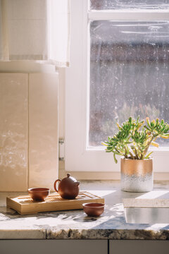 Kitchen interior with marble countertop and chinese tea set by window