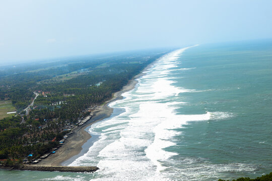 high-angle view of a long endless coastline with strong white waves
