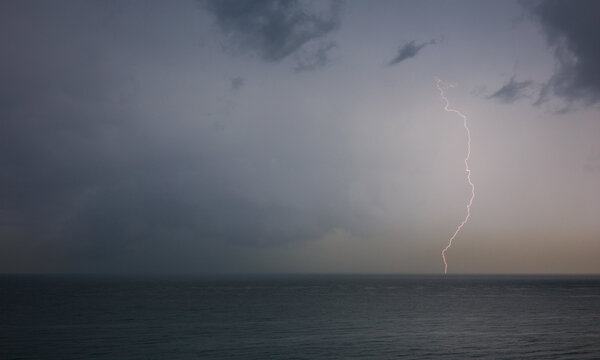 Lightning flashes and storm clouds over the sea	
