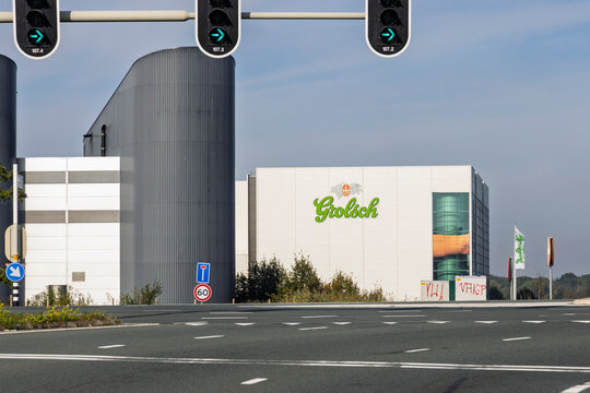 Enschede, Netherlands - October 02, 2026: Exterior facade of the Grolsch beer brewery building featuring the company logo near a road intersection with traffic lights.
