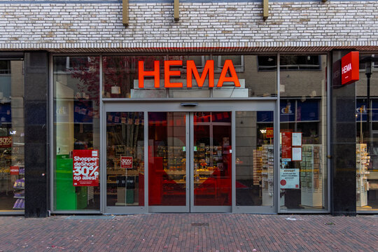 Kerkrade, Netherlands - October 04, 2026: Exterior view of a HEMA retail store entrance displaying discount sales banners on the automatic glass sliding door.