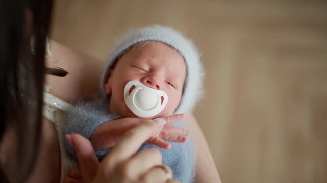 Mom Rocking And Stroking Newborn Baby From Above