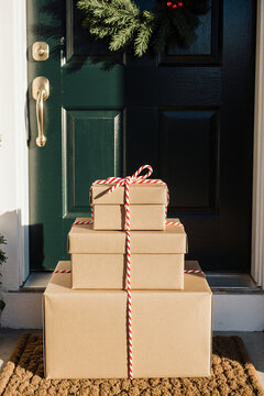 Holiday delivery parcels tied with twine at a green front door with wreath