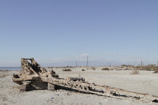 An abandoned crane sits on the shore of the Salton sea rusted and deteriorating from the harsh conditions and salty sea air
