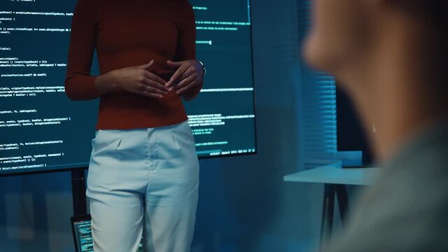 Diverse team software developer present coding on screen to colleague at office night. Mentor coach program leader, Creative startup teamwork discuss, Artificial intelligence system workshop concept.
