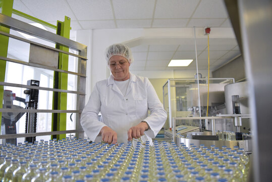 medical products manufacturing in a modern factory - glass bottles with medications on conveyor belt