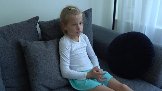 A girl watches a cartoon intently, her gaze fixed on the screen as her pupils follow the plot and she fidgets with her fingers anxiously. Child psychology articles, media impact studies