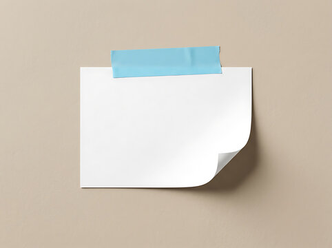 Blank white paper note with blue tape on beige wall
