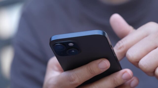 man holds smart phone in her hands and scrolls through the news feed. Close up of hand uses mobile. point finger on screen, texting text message.
