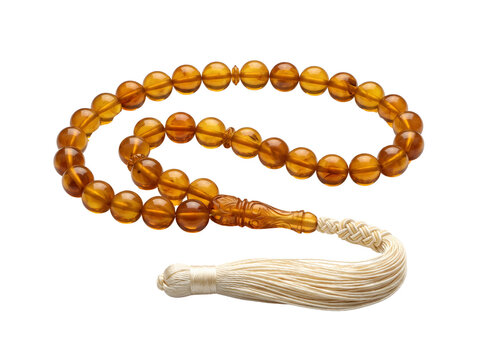 Misbaha rests neatly on a clean transparent surface with smooth amber beads and a delicate white tassel.
