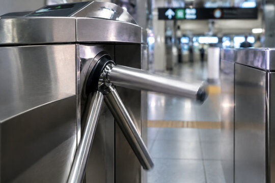 Close-up of a stainless steel turnstile arm rotating at a subway entrance, clean surfaces.
