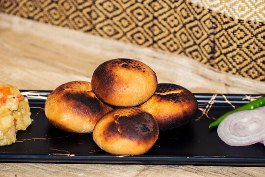 Sattu litti on a black palte, famous food from Bihar and UP. 