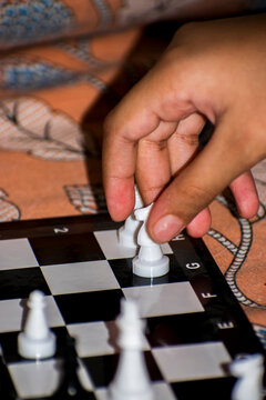 child hand serving white horse in chess