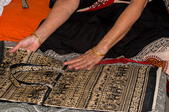 elderly indian woman making bag as small scale business from home. 