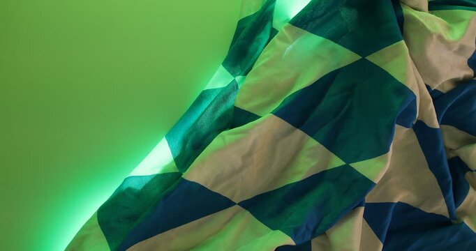 Abstract checkered fabric illuminated with vibrant neon gradient light