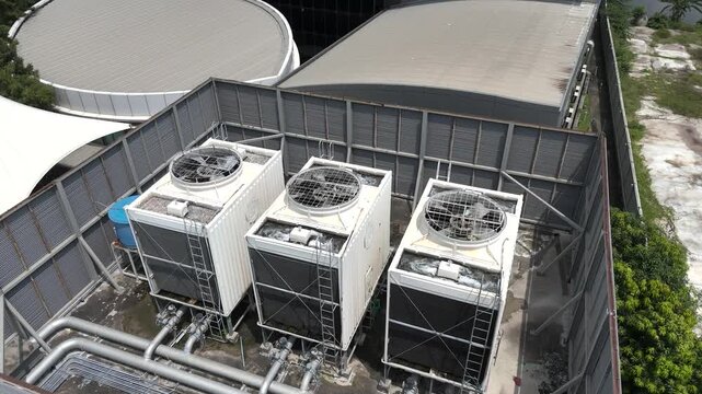 High-angle view of a cooling tower operating on a building rooftop.