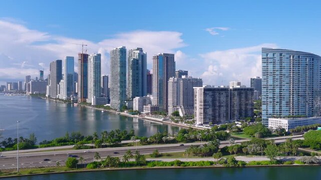 Aerial view of the Julia Tuttle Causeway and the Miami skyline with modern skyscrapers, calm bay waters, and lush greenery in Miami, Florida, United States.