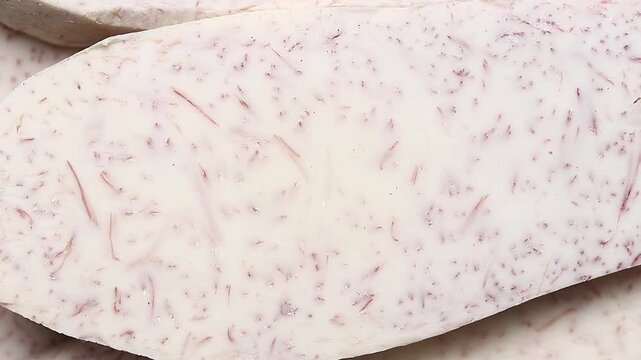 Raw taro root flesh texture slowly rotating. Top view shot