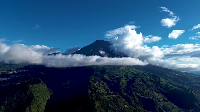 Drone footage looks down into a rocky river channel winding through dense forest in Tungurahua, Ecuador. Pale stones and boulders fill much of the channel, with small patches of water between steep, d