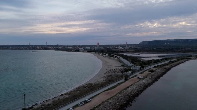 Aerial view of the coastal industrial area with a road separating the sea in Augusta, Sicily, Italy.