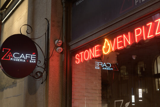 exterior building facade and neon sign of Za Cafe Pizzeria & Bar located at 372 Bay St at night in Toronto