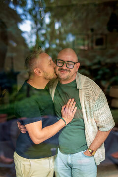  Same-sex male couple embracing and kissing each other