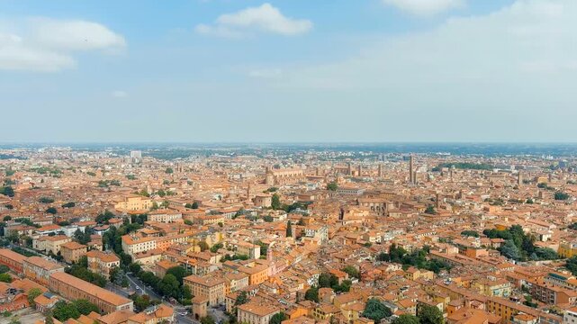 Bologna, Italy. Panoramic Drone footage over the medieval old town, terracotta rooftops and historic leaning towers under bright summer sky, elevated cityscape perspective. Drone footage