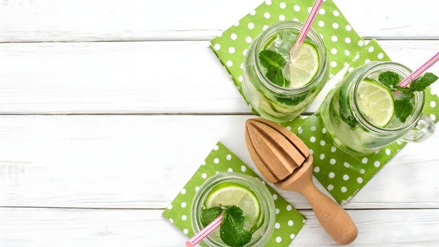 Refreshing Summer Lime and Mint Drinks in Mason Jars on White Wooden Table