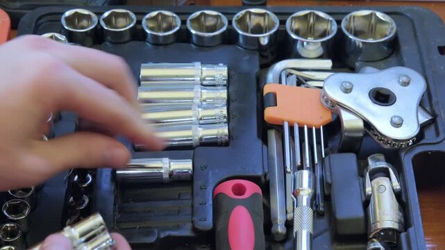 Hand selecting tools from a toolbox for a repair task in a workshop