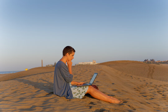 Woman thinking while working on laptop outdoors