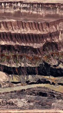Aerial view of the vast Garzweiler surface mine showing deep excavated layers of earth and sediment in Juchen, North Rhine-Westphalia, Germany.