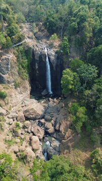 Aerial Drone Footage of Waterfall Flowing Through Lush Tropical Forest