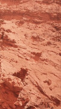 Reddish rock formations dominate the landscape under a clear sky. The terrain is rugged with various shapes and textures. This scene captures a unique planetary surface.