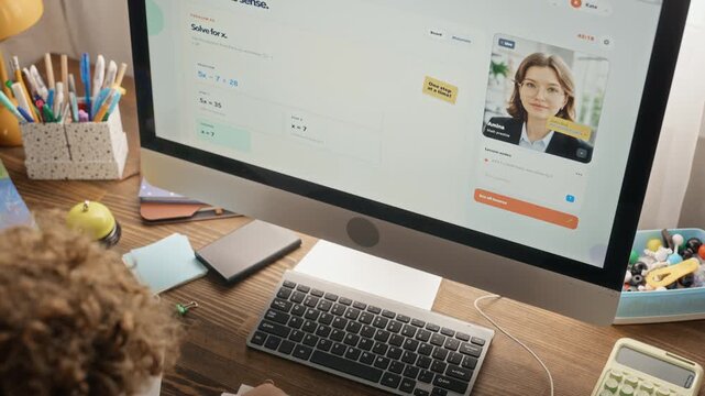 Caucasian teenager studying online with female tutor on computer screen, writing math test. Footage fits e learning platform promotions, distance tutoring ads and educational campaigns