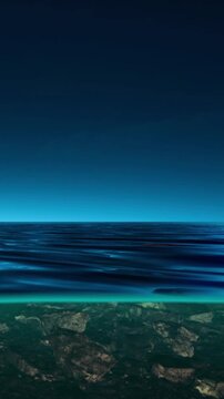 A wide view shows the ocean at sunset. The sky is filled with colors while gentle waves ripple on the surface. The horizon blends with deep blues and oranges above the water.