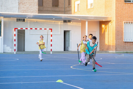 Primary school children playing floorball on playground