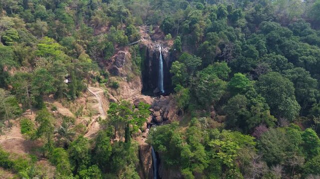 Aerial Drone Footage of Waterfall Flowing Through Lush Tropical Forest