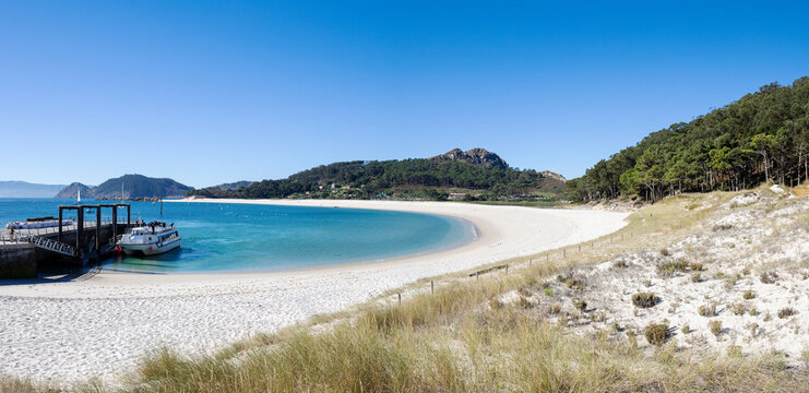 panoramic view of rodas beach, pier and tourist catamaran at cies islands natural park in galicia spain