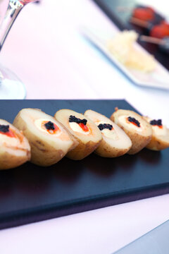  Mini aperitivos de patatas con aderezos en bandeja oscura, tapas. Mini bocados de patatas rellenas en bandeja oscura; Aperitivos de tapas espa&ntilde;olas para men&uacute; de restaurante, alimentos y aperitivos